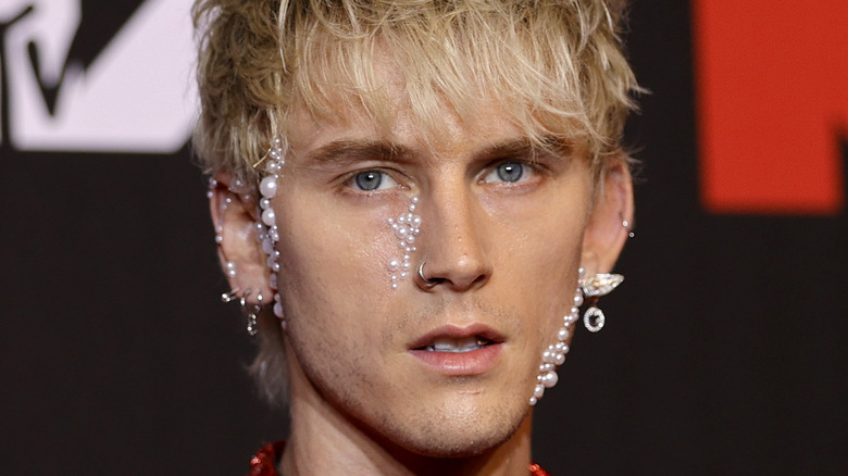 Machine Gun Kelly wearing pearls on face