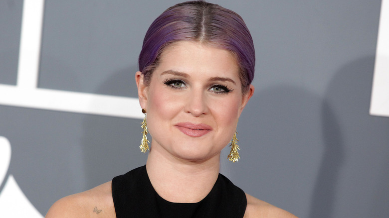 Kelly Osbourne with purple hair and smiling