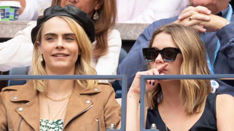 Ashley Benson and Cara Delevingne sitting together in the stands 