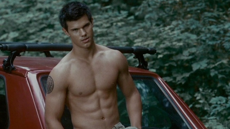 Jacob Black leaning against a car, standing shirtless