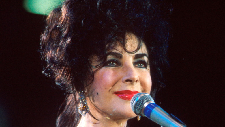 Elizabeth Taylor smiling behind mic