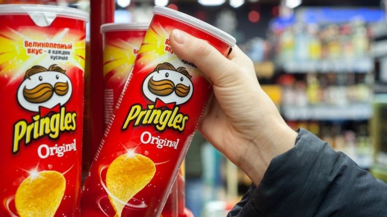 Person grabbing Pringles can off shelf