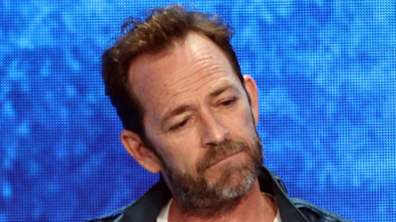 Luke Perry looking down to the side