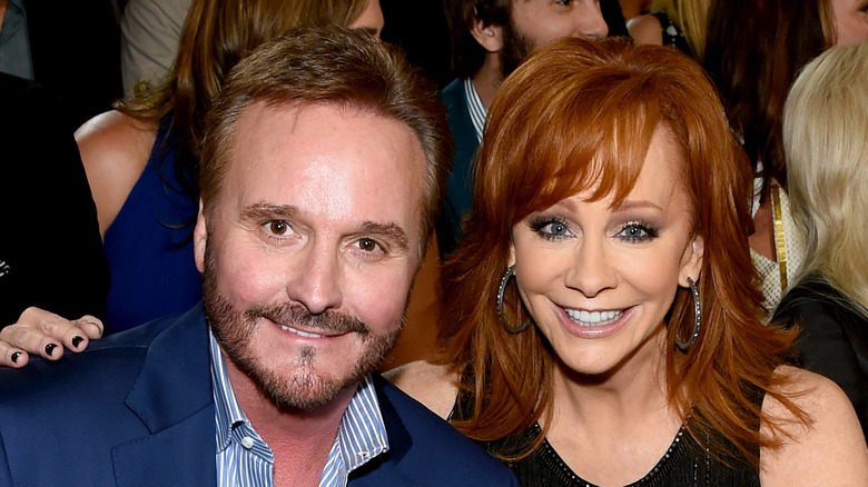 Narvel Blackstock and Reba McEntire posing while seated