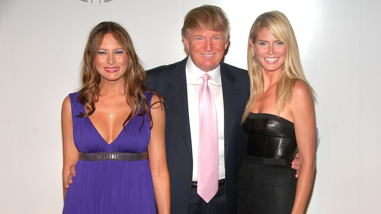 Donald Trump standing between Melania Trump, Heidi Klum