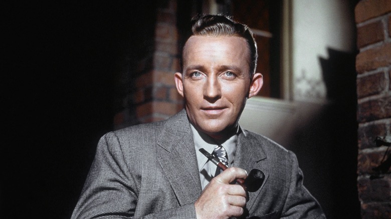 Bing Crosby posing holding a pipe