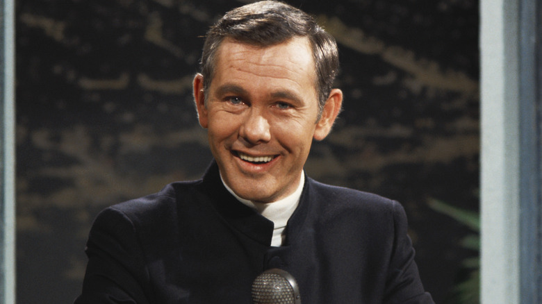 Johnny Carson smiling at his desk