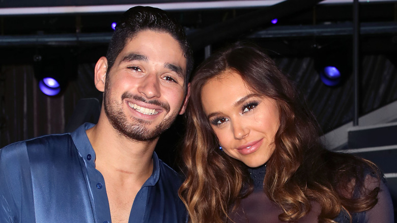 Alan Bersten and Alexis Ren leaning heads together