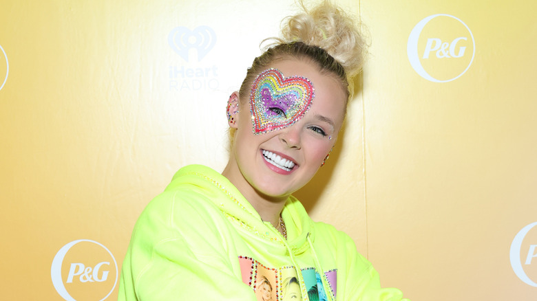 JoJo Siwa smiling with rainbow heart around eye