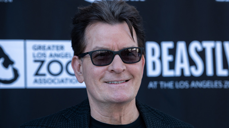 Charlie Sheen smiling in sunglasses in 2023