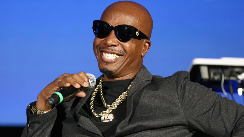 MC Hammer wearing a gray suit and gold chains