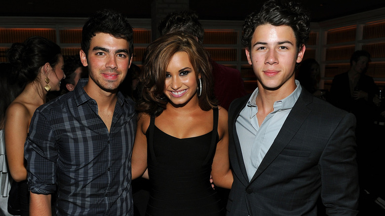 Demi Lovato posing between Joe, Nick Jonas