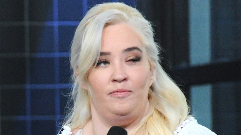 Mama June Shannon in a white outfit, grimacing during an interview