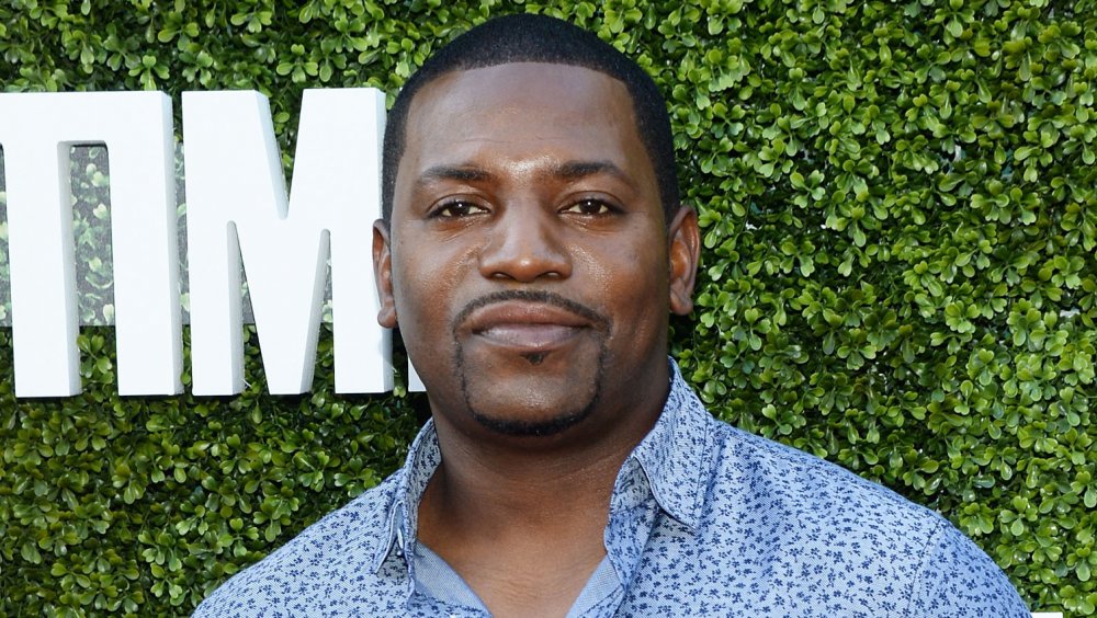 Mekhi Phifer wearing a blue-printed button-down shirt, posing with a neutral expression