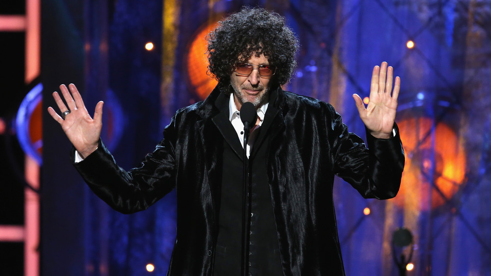 Howard Stern holding his hands up 