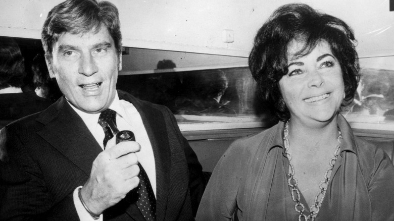 John Warner holding pipe, Elizabeth Taylor smiling