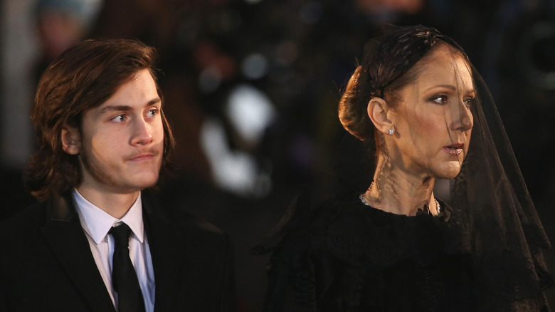 Rene-Charles Angelil stands next to his mother at Rene Angelil's funeral