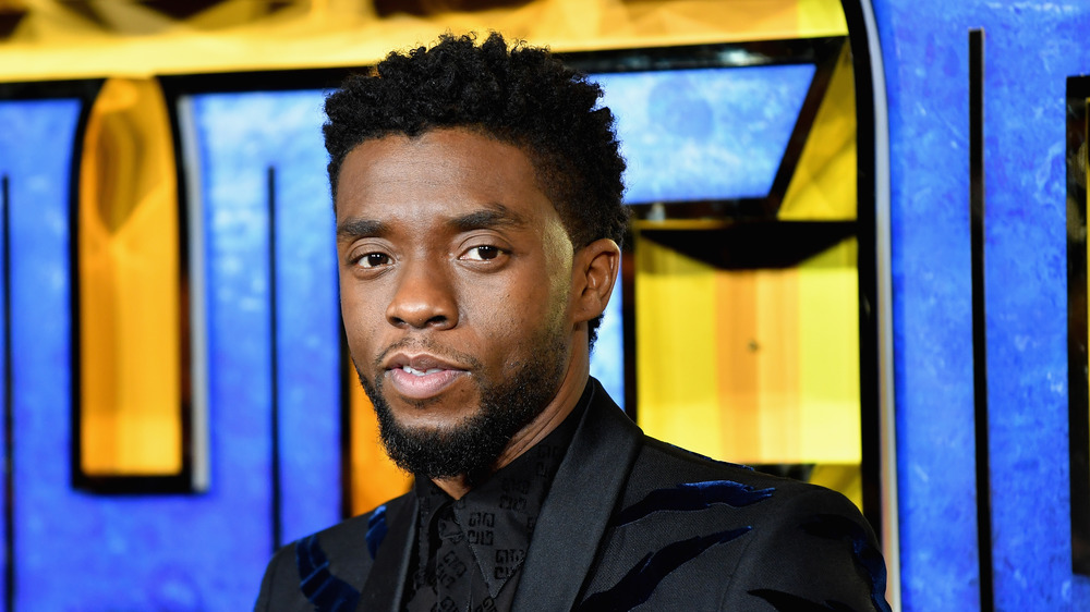 Chadwick Boseman posing black suit