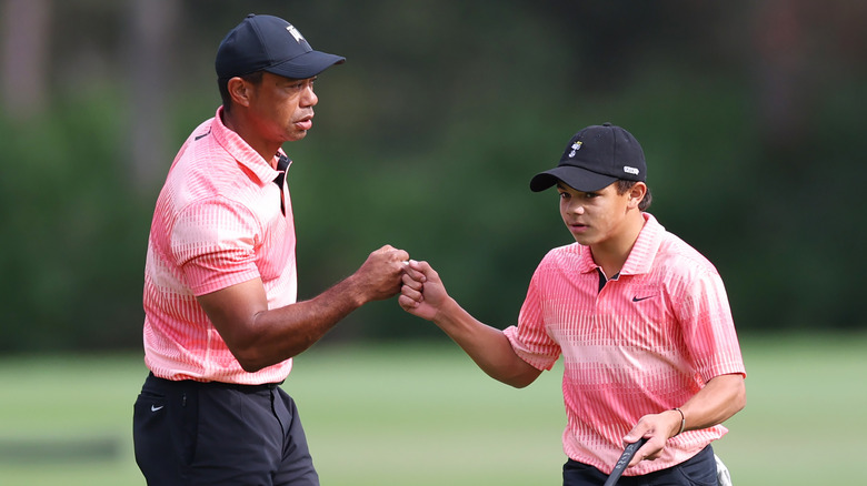 Tiger and Charlie Woods fist-bumping on the green