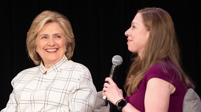 Hillary Clinton and Chelsea Clinton smile on stage