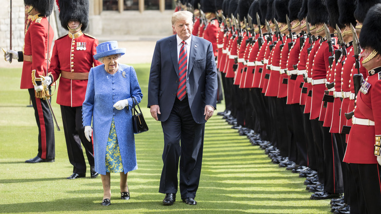 Donald Trump walking with Queen Elizabeth II