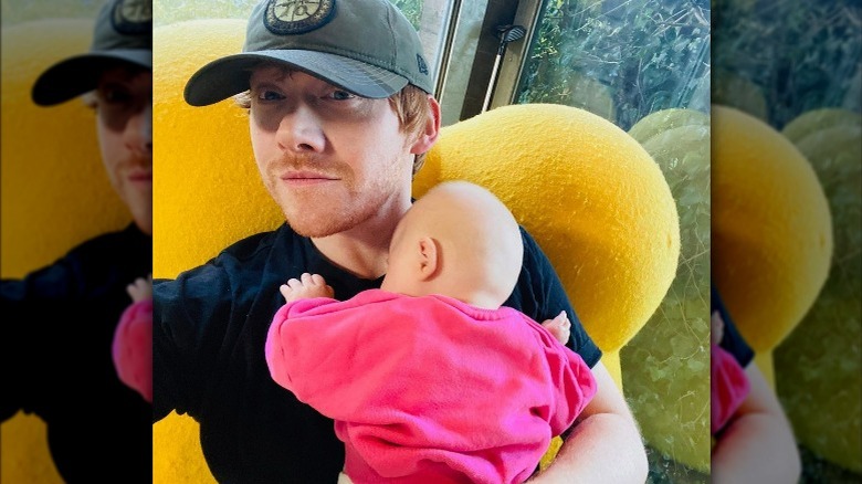 Rupert Grint holding baby daughter