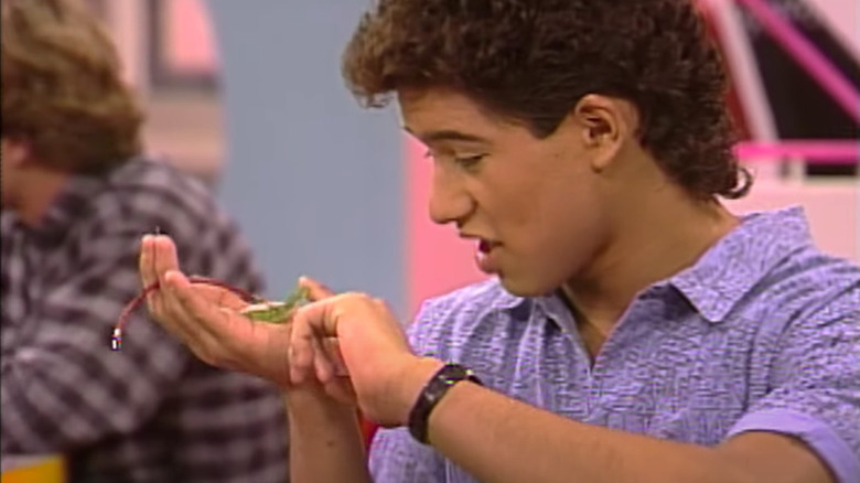 Young Mario Lopez holding a baby frog