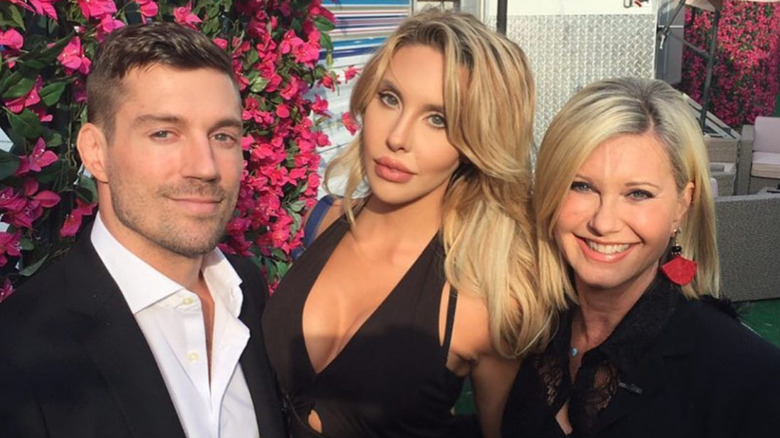 Chloe Lattanzi, James Driskill, and Olivia Newton-John pose for a photo 