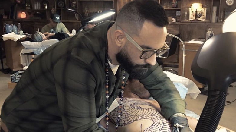 Chris Núñez giving a tattoo