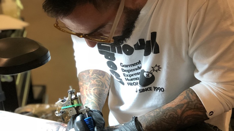 Chris Núñez giving a tattoo