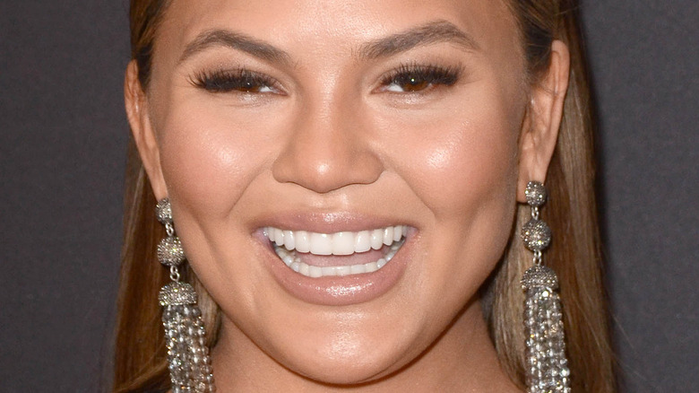 Chrissy Teigen smiling on the red carpet