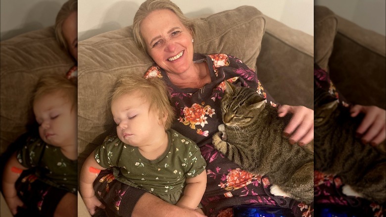 Christine Brown poses with her grandchild and cat