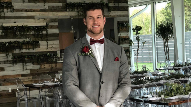 Clayton Echard smiling in a suit