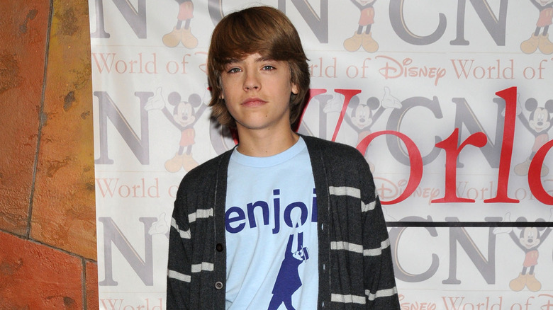 Cole Sprouse in front of Disney banner 