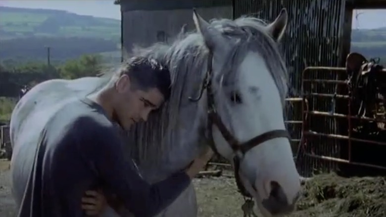 Colin Farrell hugging a horse in a scene from Ballykissangel