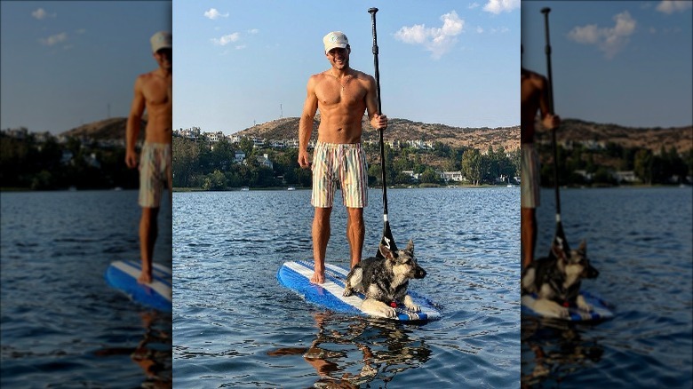 Colton Underwood poses on a paddleboard 