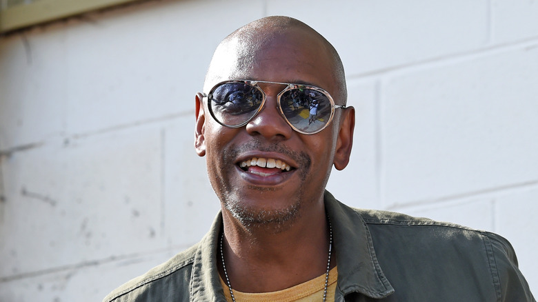 Dave Chappelle outside, smiling