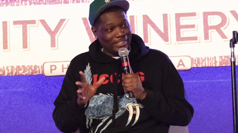 Michael Che on stage, performing
