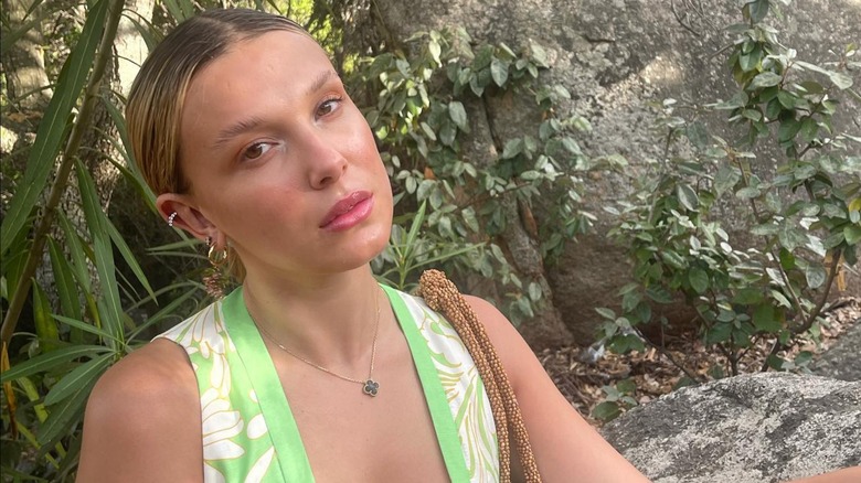 Millie Bobby Brown leaning on rock