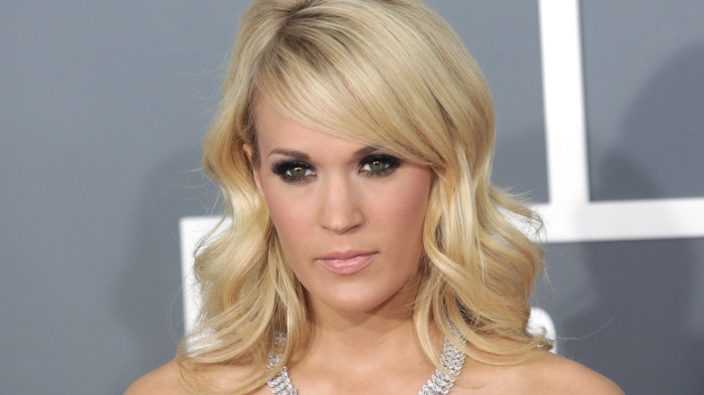 Carrie Underwood posing on the red carpet with a diamond necklace