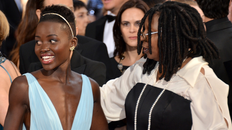 Lupita Nyong'o and Whoopi Goldberg with their arms around each other