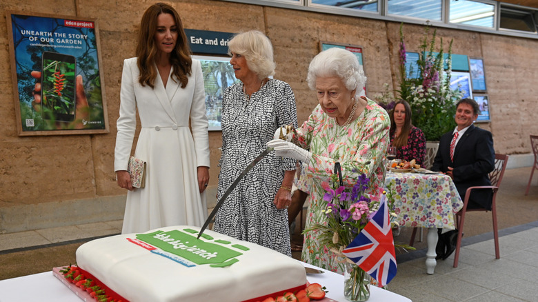 Kate Middleton with Camilla Parker Bowles and Queen Elizabeth cutting a cake