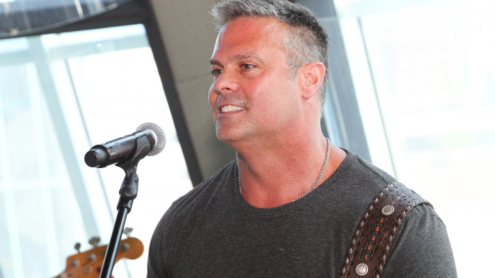 Troy Gentry in front of a microphone on stage