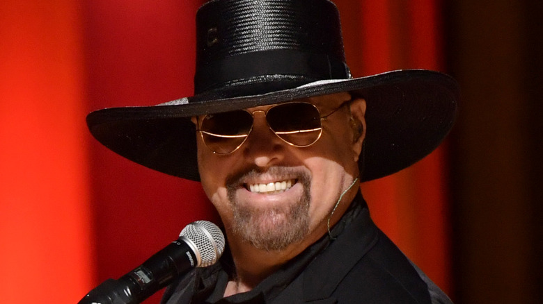 Eddie Montgomery performing in front of a red background