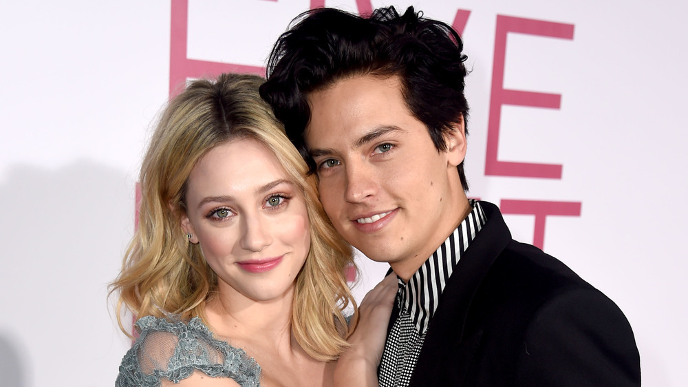 Lili Reinhart and Cole Sprouse smiling while resting their heads together