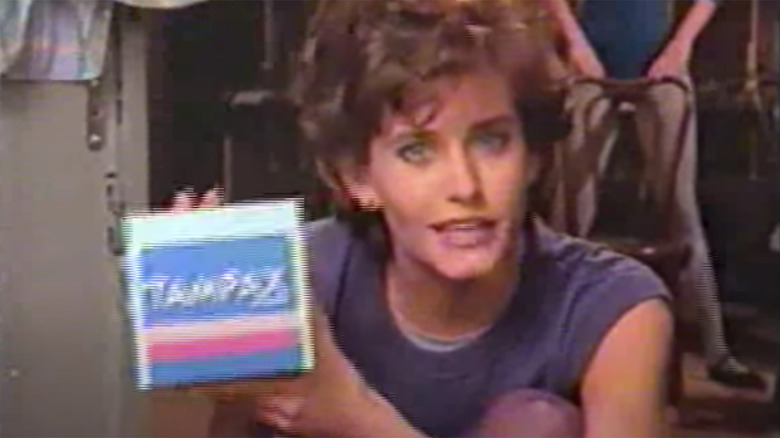 Courteney Cox in leotard holding box of Tampax tampons in commercial