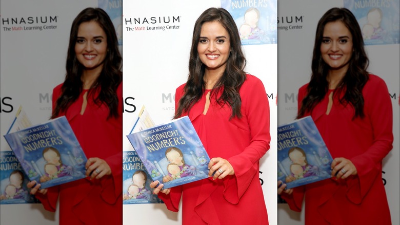 Danica McKellar posing with a book