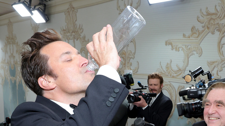 Jimmy Fallon drinking from a clear bottle