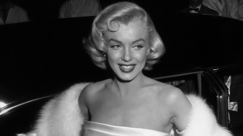 Marilyn Monroe smiling in fur in black and white