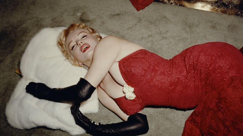 Marilyn Monroe laying down in a red dress